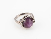 A vintage silver ring, set&nbsp;with a cabochon red star stone flanked by six brilliant cut white diamonds,