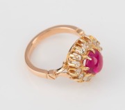 An 18ct yellow gold ring, set with a cabochon ruby surrounded by white diamonds, stamped "750", ​​​​​​​6.5 grams - 3