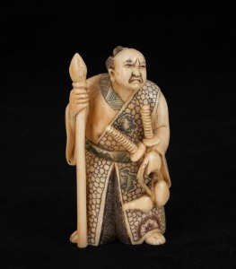 A Japanese carved ivory figure of an old samurai, late Meiji period, 9cm high