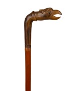 An antique walking stick with carved horn bird's head handle, cane shaft and copper ferrule, 19th century, 84cm high