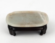 An antique Chinese white jade dish on later carved wooden stand, Chien Lung period, 18th century. Accompanied by a letter dated 29th, January, 1966 from DUNT KING (Hong Kong). 8.2cm wide