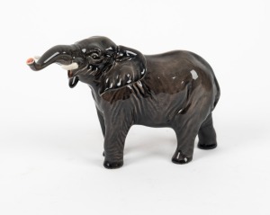 BESWICK English porcelain elephant statue with raised trunk, 20th century, black factory mark to base, 12cm high, 18cm long