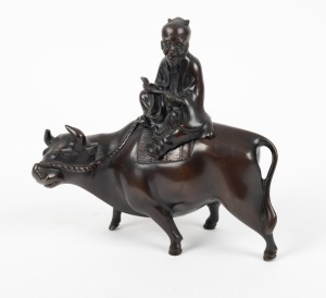 A Chinese bronze statue of a seated scholar on a buffalo, 20th century, 20cm high