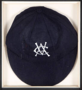 VICTORIA CRICKET CAP, navy blue with embroidered "VCA" monogram on front, window mounted, framed & glazed, overall 34x38cm. G/VG condition.