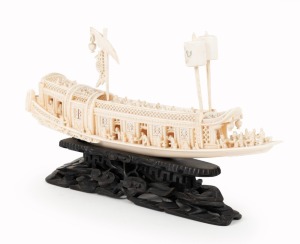 A Chinese carved ivory barge ornament on carved timber stand, early to mid 20th century, ​​​​​​​20cm high, 35cm long overall