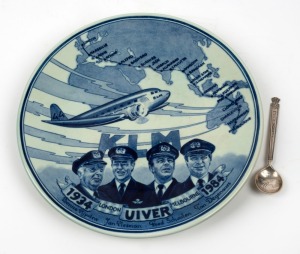 THE LONDON to MELBOURNE, MacROBERTSON CENTENARY AIR RACE 1934: Souvenir silver tea-spoon with "KLM UIVER" to the handle, the dates, route and a stork to the bowl. (11cm long); Also, a 50th Anniversary porcelain hanging plaque by Regina Delfts Blauw, Oosterwijk, depicting the UIVER, her crew, and the complete route flown in 1934 from London to Melbourne. (2 items).