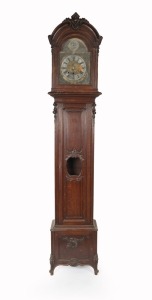 An antique French oak long case clock, circa 1860. With floral carved decoration, applied oggee mouldings to the panels and lenticel glass to the trunk door. The weight driven Comtoise style movement striking on a coiled gong with associated brass break arch dial with pewter spandrels and maker's signature boss to the arch. 245cm high, 48cm wide, 30cm deep