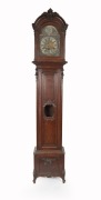 An antique French oak long case clock, circa 1860. With floral carved decoration, applied oggee mouldings to the panels and lenticel glass to the trunk door. The weight driven Comtoise style movement striking on a coiled gong with associated brass break a