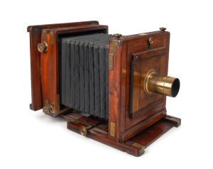 23 x 23cm plate tailboard camera with Dallmeyer Triple Achromatic lens [#14138], leather bellows, rack-focusing mechanism, blank ivorine plate for retailer's inscription on top surface, and two spare fitting flanges.