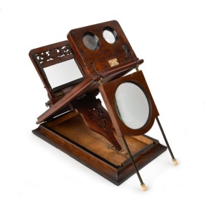 Stereo graphoscope featuring stereo viewer on hinged platform and fold-away magnifying postcard viewer, c. 1870, with beautiful carved floral details and 'Fred K. Cox 98 Newgate St London' retailer's plaque.