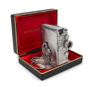 BOLSEY: USA-version Bolsey 8 dual photo/movie camera [#03770], c. 1956, with Navitar 10mm f1.8 lens, wrist chain, presentation box, and printed matter. Matching the size of a cigarette packet, the Bolsey 8 was marketed as 'The World's Smallest Movie Camer