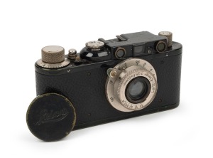 LEITZ: Black-body/chrome-fittings Leica II Model D rangefinder camera [#86985], c. 1932, with Elmar 50mm f3.5 lens, front lens cap, and leather case.