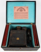 ERNST PLANK: Children's magic lantern, height 24.5cm, in maker's wooden box with eleven glass slides, c. 1890s. - 2