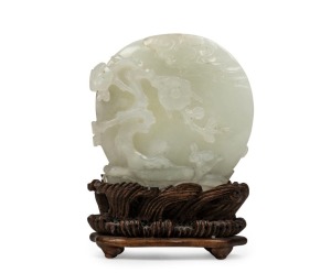 An antique Chinese jade ornament carved with blossom tree, on carved timber stand, Qing Dynasty, 18th/19th century, 8cm high overall