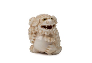 A Japanese carved ivory mythical lion netsuke, Meiji Period, two character mark to base, 4cm high