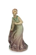 MARGUERITE MAHOOD Art Deco pottery statue of a lady in a green cape, incised "Marguerite Mahood, F1363", 21.5cm high