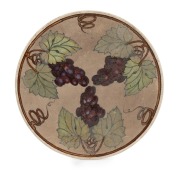 MARTIN MORONEY&nbsp;circular pottery plaque with hand-painted grapes and vines, signed "M. MORONEY, BRISBANE, 1905", with "Q.M." monogram, ​​​​​​​29cm diameter