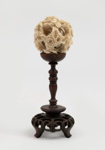 An antique Chinese carved ivory puzzle ball on turned rosewood stand, in fitted timber box, early 20th century, 15cm high including stand