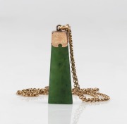 An antique New Zealand greenstone and 9ct gold pendant, suspended on a later 9ct gold chain, 19th and 20th century, the pendant 4cm high, the chain 50cm long, 3.7 grams