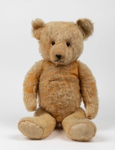 A vintage English straw filled teddy bear, mid 20th century, 57cm long