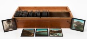 Wooden box containing thirty-one 8 x 8cm glass slides featuring colourised photographs of&nbsp;cities and coastal features in&nbsp;Devon and Cornwall. (31 items)