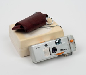 ROLLEI: Rollei E110 cartridge camera, c. 1976, with Tessar 23mm f2.8 lens [#3233884], flash attachment, leather case, and matching box.