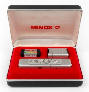 MINOX: Minox C subminiature camera [#2407479], c. 1970s, with Minox 15mm f3.5 lens. Offered in maker's case with C4 flash accessory, leatherette cases for both camera and flash unit, chain, film canister, and two instruction booklets.