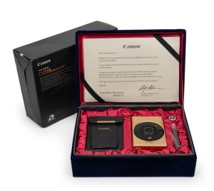 CANON: Limited-edition gold-body IX240 compact camera [#004077], c. early 2000s. Presented in maker's box with velvet-lined inner box, certificate of authenticity, instruction booklet, warranty card, leather case, battery, and RC-5 remote control.