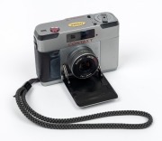 YASHICA: Contax T rangefinder camera [#030581], c. 1984, in silver with Carl Zeiss Sonnar T 38mm f2.8 lens. Offered in maker's box with Contax T14 Auto flash accessory, suede case, wrist strap, and printed materials. - 2
