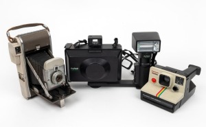 POLAROID: Three instant film cameras - one Model 80A Land Camera in grey, one Supercolor Onestep with wrist strap, and one ProPack Camera with ProFlash attachment and wrist strap. (3 items)