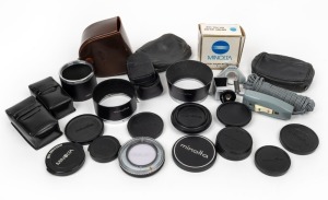 MINOLTA: Accumulation of twenty-four photography accessories, comprising three metal lens hoods, ten lens caps, six leather pouches, one AC 1B Skylight lens filter in case, one BH-70L Battery Holder in maker's box, one Minoltina remote control, one access