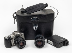 MINOLTA: Dynax 500si SLR camera in silver, c. 1993, in leather case with two lenses, Auto 32B Sunpak flash attachment, and lens filter.