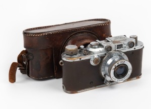 LEITZ: Chrome Model F Leica III [#139050 - corresponding to 1934], with Elmar 50mm f3.5 lens and with brown leather Leica case. Defaced Reichsadler symbol and anomalous 'M 66' engravings present above serial number on top plate likely to be fanciful addit