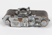 LEITZ: Chrome Model F Leica III [#139050 - corresponding to 1934], with Elmar 50mm f3.5 lens and with brown leather Leica case. Defaced Reichsadler&nbsp;symbol and anomalous 'M 66' engravings&nbsp;present above serial number on top plate likely to be fanciful addit - 3