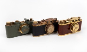 LEITZ (COUNTERFEIT): Three attractive but fanciful counterfeit 'Leicas', likely modified FED or Zorki models, each with 'Leitz Elmar' 50mm f3.5 lens and lens cap - one in gold and polished timber, one in gold and teal with fascist engraving on viewfinder,