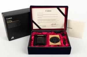 CANON: Limited-edition 18k gold-plated Ixus compact camera [#009132], c. 1997, complete with velvet-lined box, leather case, remote control, wrist strap, and printed matter. Issued to commemorate the 60th anniversary of the company.