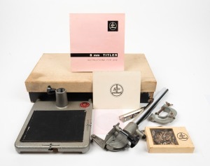 BOLEX-PAILLARD: '8mm Titler' kit in maker's box, c. 1955, comprising steel titling board with red Bolex Paillard logo, frame element, four centring cards, camera stand, box of cardboard letters, vice, instruction booklet, and various other elements.