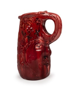 ELIZABETH EYRES unusual hand-built burgundy pottery jug decorated with flannel flowers, face mask and branch handle, incised "Elizabeth Eyres, '34", 24cm high