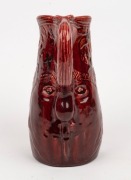 ELIZABETH EYRES unusual hand-built burgundy pottery jug decorated with flannel flowers, face mask and branch handle, incised "Elizabeth Eyres, '34", 24cm high - 2