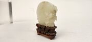 An antique Chinese jade ornament carved with blossom tree, on carved timber stand, Qing Dynasty, 18th/19th century, 8cm high overall - 7