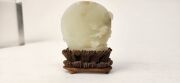An antique Chinese jade ornament carved with blossom tree, on carved timber stand, Qing Dynasty, 18th/19th century, 8cm high overall - 9