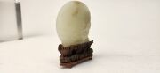An antique Chinese jade ornament carved with blossom tree, on carved timber stand, Qing Dynasty, 18th/19th century, 8cm high overall - 10