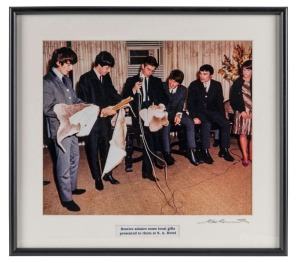 THE BEATLES IN AUSTRALIA, 1964: "Beatles admire some local gifts presented to them at S.A Hotel". Original colour print, signed by Vic Grimmett in the lower margin,  24.5 x 29.5cm, 35 x 39cm overall. 