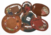 Six assorted Australiana&nbsp;Arts & Crafts hand-painted and carved leather doilies and table covers, circa 1920s, the largest 49cm diameter