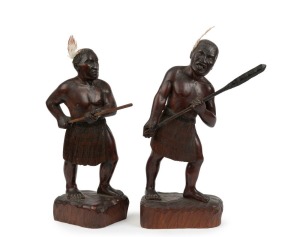 A pair of carved timber Maori warrior statues with feather decoration, 20th century, one signed to base "Hoko Pai", the larger 35cm high