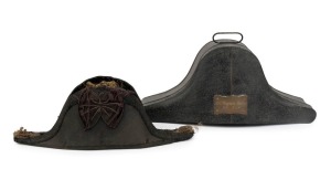 ASSISTANT SURGEON BAKER, N.B. [NAVAL BRIGADE], N.S.W.: Bicorn naval hat in original metal case with name plaque "Ass.t. Surgeon Baker, N.B., N.S.W.", the tin 26cm high, 56cm wide