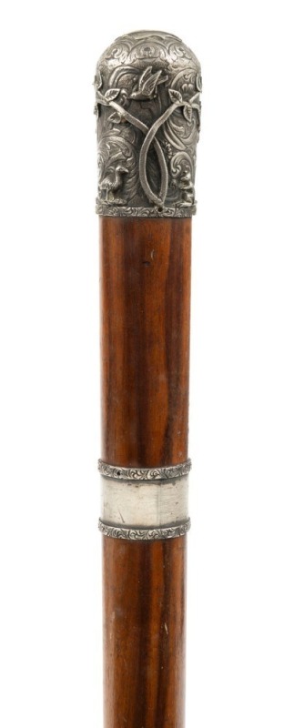 An antique walking stick with impressive Australian silver top adorned with kangaroos, emus, flying birds and trees with engraved foliate decoration, mounted on an Australian hardwood shaft with additional Australian silver collar, (no ferrule), 19th cent