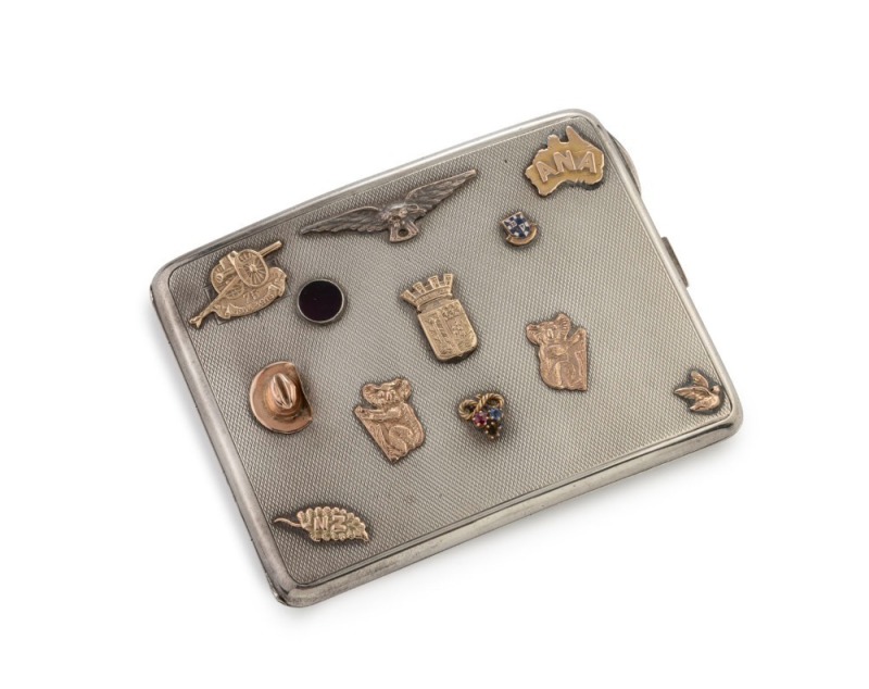 An antique Australian silver cigarette case retailed by Prouds of Sydney, adorned with numerous gold and silver charms and badges including slouch hat, koalas, New Zealand fern, artillery badge etc., engraved "Samuel Greenwald, Diamond Traders Ltd." and "