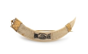 An antique New Zealand boar tusk brooch with engraved fern and "Hands Across The Sea" motif, mounted in 9ct yellow gold, 19th/20th century, stamped "EDGAR, 9ct", 10cm wide