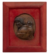 A fine antique New Zealand carved and polished kauri gum relief plaque depicting a Maori woman with chin moko carrying a child, circa 1880s, housed in original red velvet frame (worn), and bearing paper label&nbsp;verso "Thomas's Picture Frame Manufactory, Syd